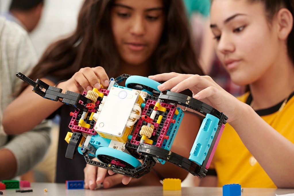 Two teenage students building a large robotic vehicle using LEGO Education SPIKE Prime